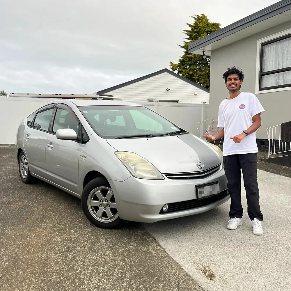 Devesh standing beside the silver Prius on his driveway